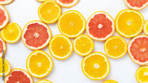 Fruity summer citrus background. Oranges, grapefruit and kiwi sliced on a white background