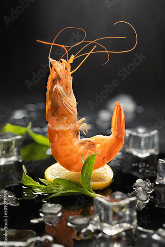 Flying prawns on lemon on dark background with ice. Creative design of seafood cooking concept.