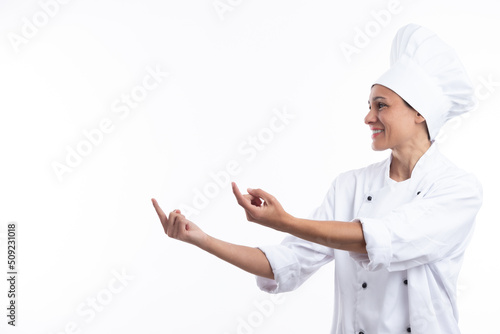 Woman chef pointing with fingers isolated on white background with copy space.