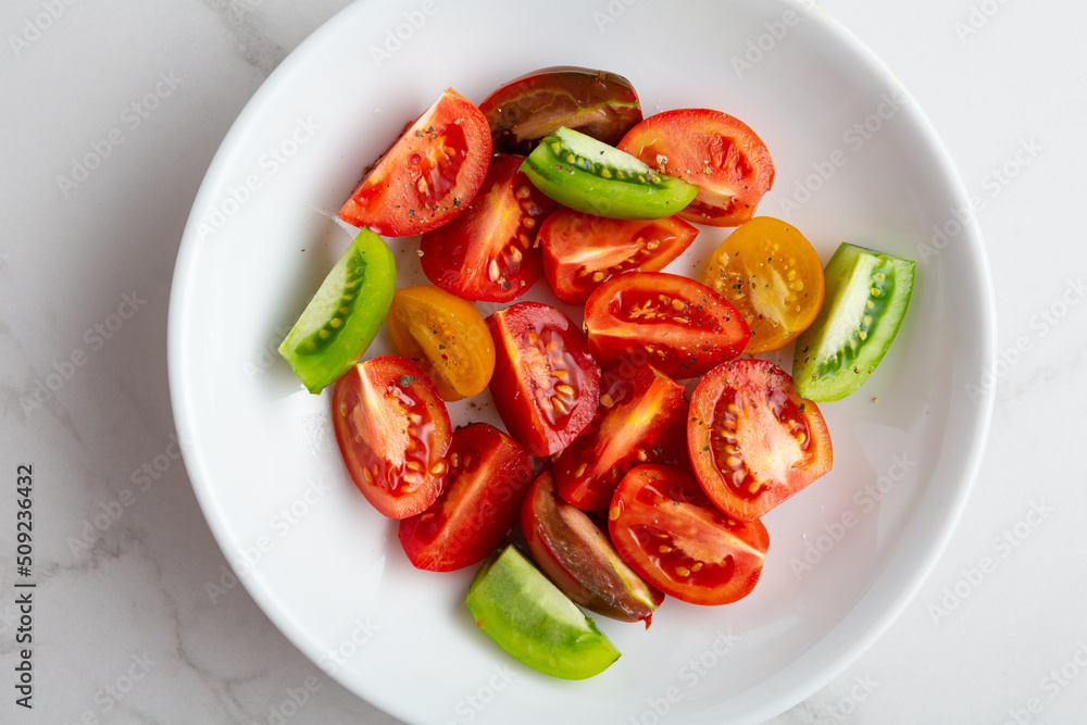 Overhead view of sliced tomato in white bowl Overhead view of sliced tomato in white bowl