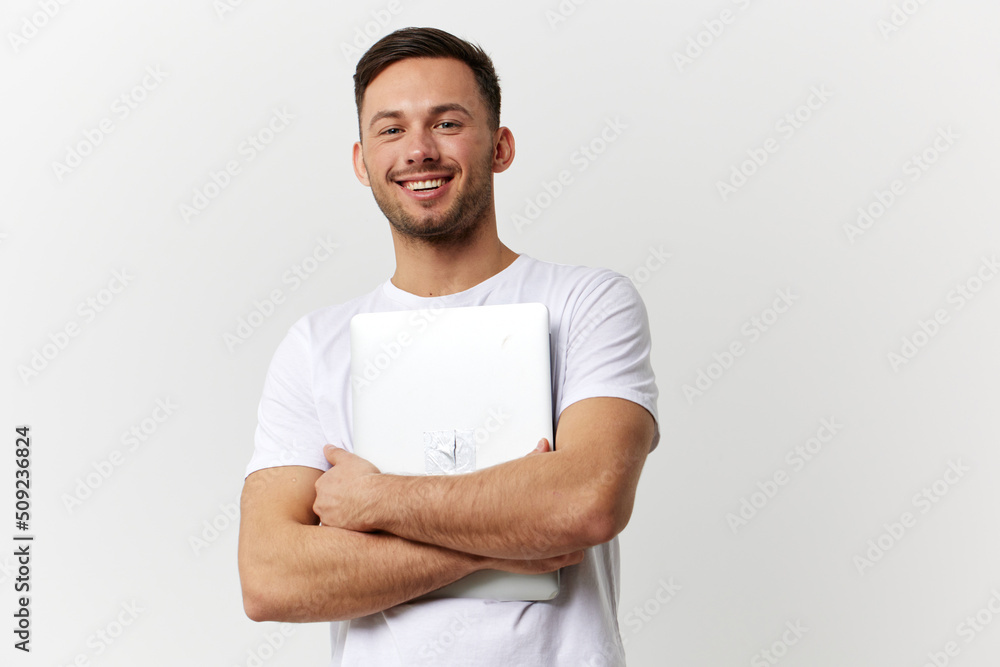 Cheerful happy tanned handsome man in basic t-shirt hugging with laptop pc posing isolated on over white studio background. Copy space Banner Mockup. Electronics repair Gadget lifestyle concept Cheerful happy tanned handsome man in basic t-shirt hugging with laptop pc posing isolated on over white studio background. Copy space Banner Mockup. Electronics repair Gadget lifestyle concept