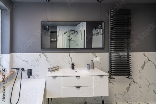 Modern flat bathroom with grey walls and white bath