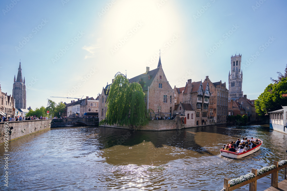 Obraz premium Canal in Bruges and Belfry tower - Houses and Streets - Bruges, Belgium - the city centre