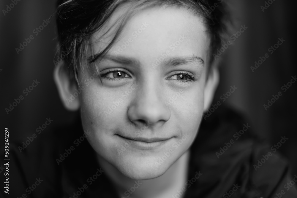 Black and white portrait of teenage boy on dark background. Low key close up shot of a young teen boy. Black and white photography. Selective focus Black and white portrait of teenage boy on dark background. Low key close up shot of a young teen boy. Black and white photography. Selective focus