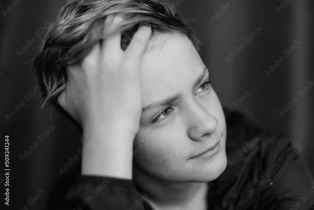 Black and white portrait of teenage boy on dark background. Low key close up shot of a young teen boy. Black and white photography. Selective focus Black and white portrait of teenage boy on dark background. Low key close up shot of a young teen boy. Black and white photography. Selective focus