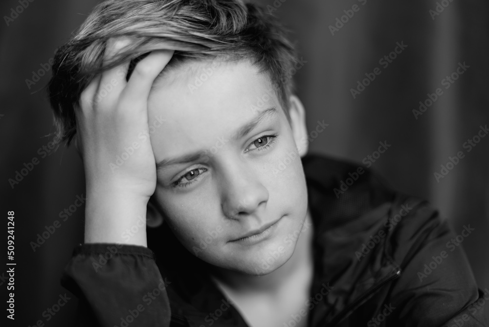 Black and white portrait of teenage boy on dark background. Low key close up shot of a young teen boy. Black and white photography. Selective focus Black and white portrait of teenage boy on dark background. Low key close up shot of a young teen boy. Black and white photography. Selective focus