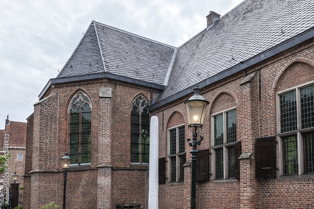 Intimate Chapel from 1390 with its beautiful arched windows and men's hall (Mannenzaal) behind it - remained from medieval building of St. Pieters en Bloklands Gasthuis. Amersfoort, the Netherlands. Intimate Chapel from 1390 with its beautiful arched windows and men's hall (Mannenzaal) behind it - remained from medieval building of St. Pieters en Bloklands Gasthuis. Amersfoort, the Netherlands.