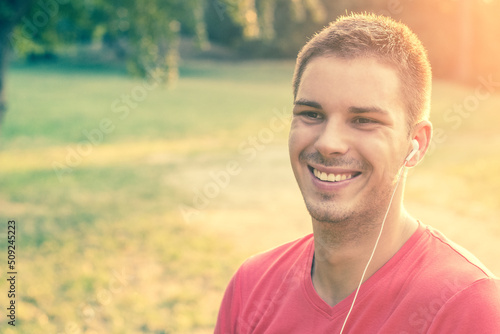 Beautiful man with headphones, outdoors, nature