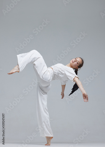 Beautiful young modern dancer or fitness dancer on a white isolated background