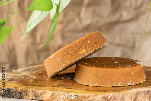 Colombian panela or sugar cane candy, ready to be consumed in various typical dishes. piloncillo ready for sale and marketing, placed on a wooden board and surrounded by green leaves. photo