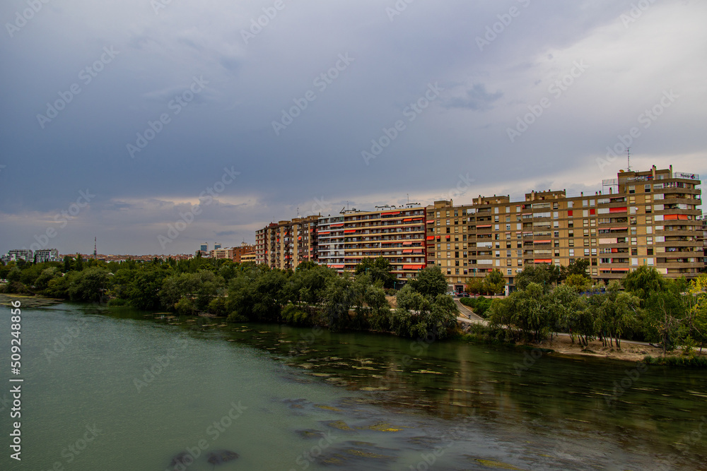 lof the Ebro river and apartment blocks in Zaragoza, Spain on a cloudy summer day