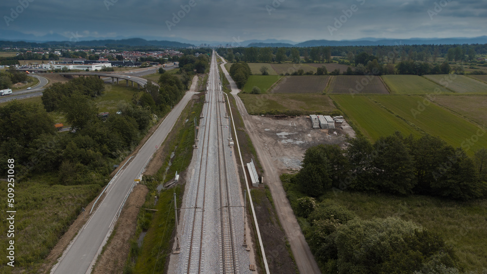 Freshly renovated train track leading towards the city centre of Ljubljana, around Brezovica. Modern train track next to a motorway or highway.