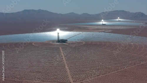 Aerial view of solar thermal plant. Large circular power plant of solar panels. Alternative energy solar power farm creating electricity in open desert field.  Solar panels field (solar cell). 4K photo