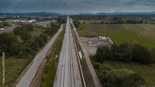 Freshly renovated train track leading towards the city centre of Ljubljana, around Brezovica. Modern train track next to a motorway or highway.