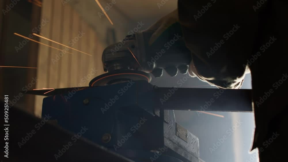 Blacksmith cutting metal using angle grinder while working in industrial workshop. High quality 4k footage Blacksmith cutting metal using angle grinder while working in industrial workshop. High quality 4k footage