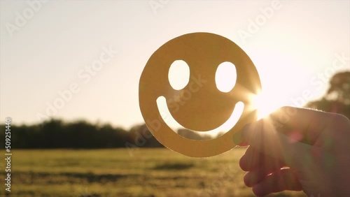 Wallpaper Mural Close up of female hand holding yellow happy smile face on background amazing sunset or sunrise, good feedback rating and positive customer review, satisfaction survey, mental health assessment Torontodigital.ca