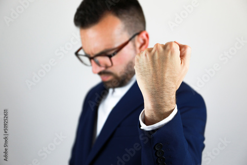 Handsome boy in a nice blue suit, highlighting his left hand to celebrate left-handers day.