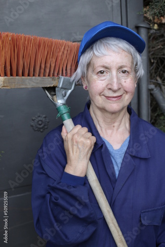 Senior female street cleaner with broom