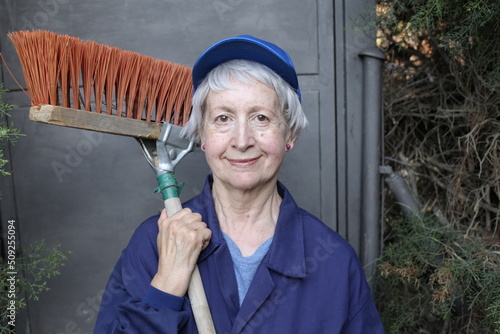 Senior femaler street cleaner with broom photo