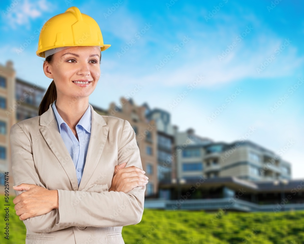 Young woman wearing architect hardhat against background Young woman wearing architect hardhat against background