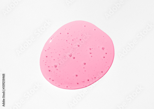 Pink cosmetics gel, serum or peeling drop on grey background. Colorful slime with air bubbles in the sunlight. High contrast trendy photo. Health protection, skin care concept