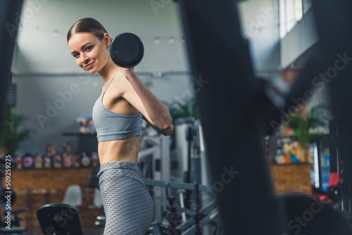 Indoor gym shot of a proud strong caucasian young adult woman at the gym, lifting barbell. Fitness concept. High quality photo