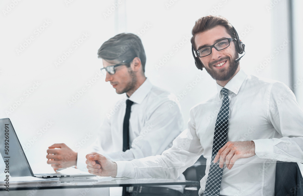 Obraz premium Manager with the headset works in a modern office