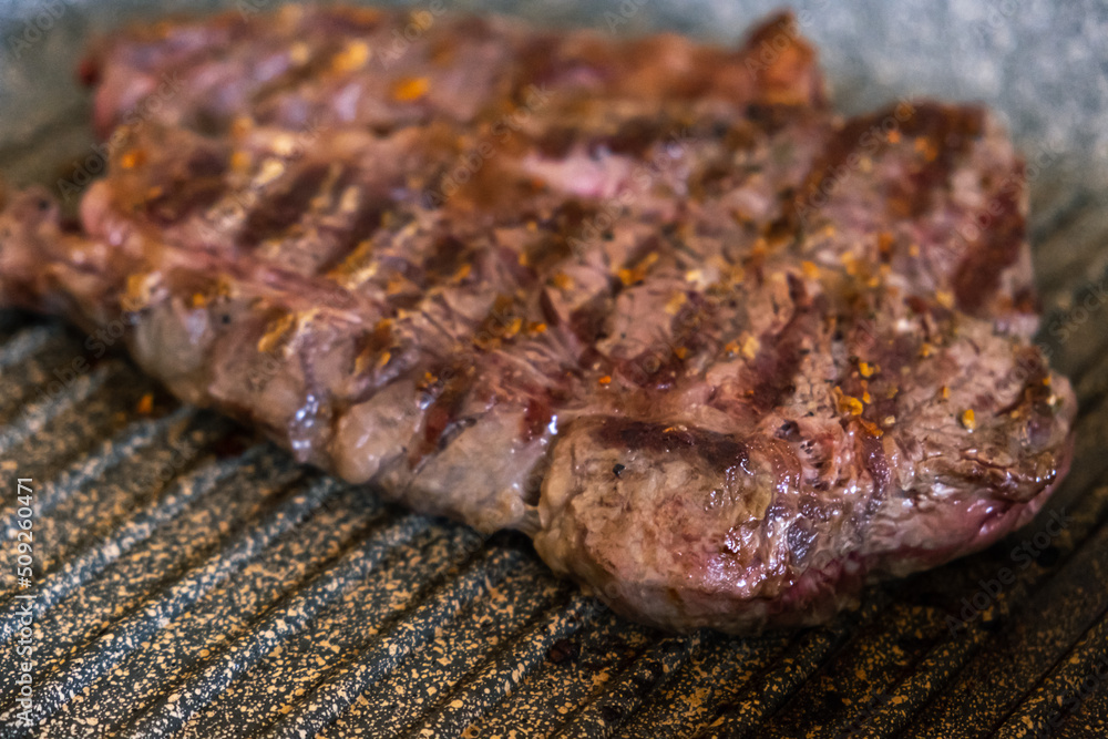 Juicy beef meat steak cooking on griddle pan at professional kitchen. Prime steak frying at grill. Delicious, modern cuisine Juicy beef meat steak cooking on griddle pan at professional kitchen. Prime steak frying at grill. Delicious, modern cuisine