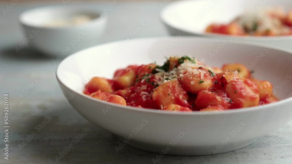 Gnocchi with tomato sauce and parmigiano on a plate Gnocchi with tomato sauce and parmigiano on a plate