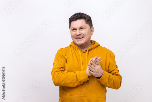 Portrait of attractive dreamy hopeful man of middle age dreaming thinking, meditating imaging bright future, wearing urban style hoodie. Indoor studio shot isolated on white background.