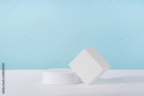 Podium pedestal for cosmetic product packaging on blue background. Showcase for jewellery presentation, white platform for perfume advertising, cosmetics stand background, branding scene mockup