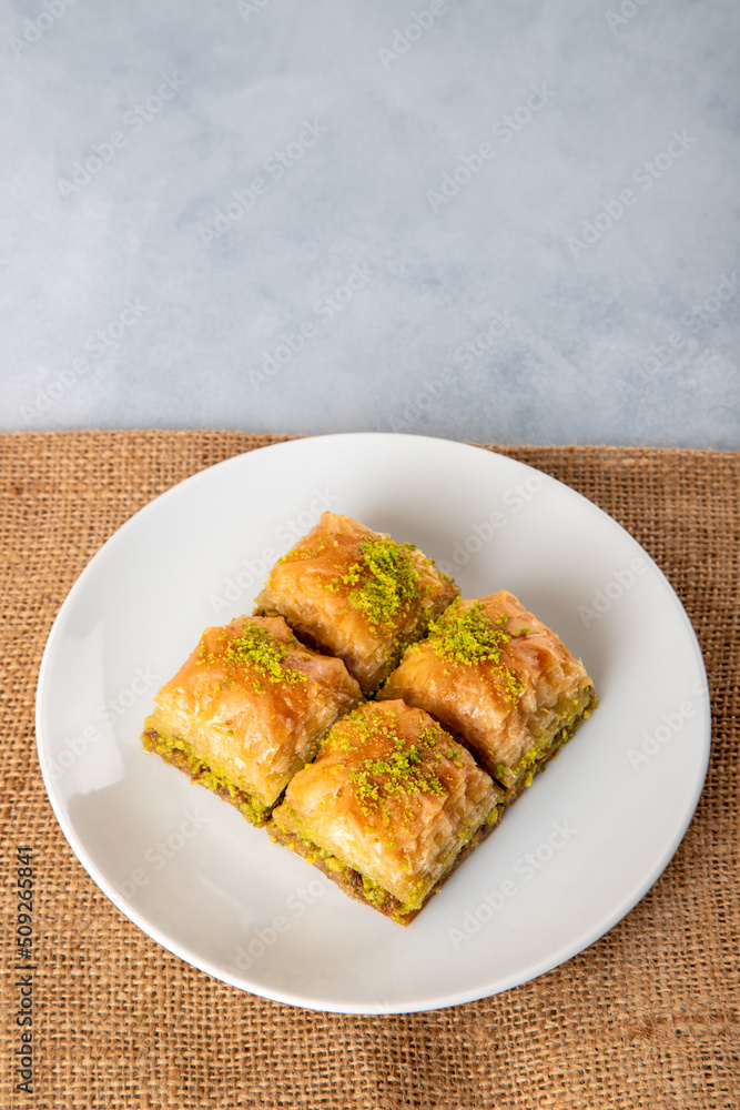 Pistachio baklava on a white plate.A plate baklava on bright background Pistachio baklava on a white plate.A plate baklava on bright background