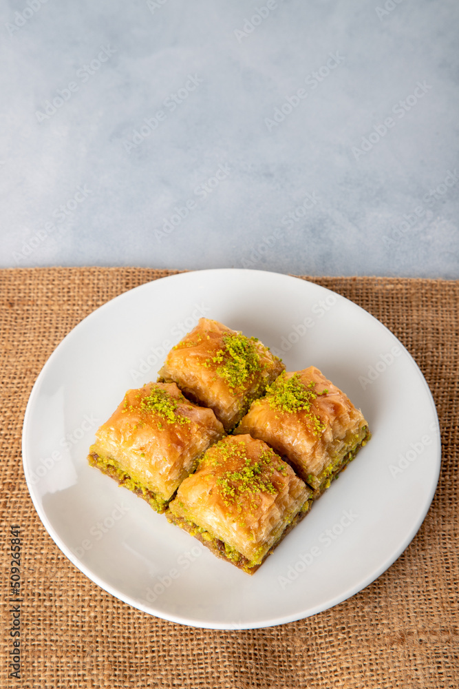 Pistachio baklava on a white plate.A plate baklava on bright background