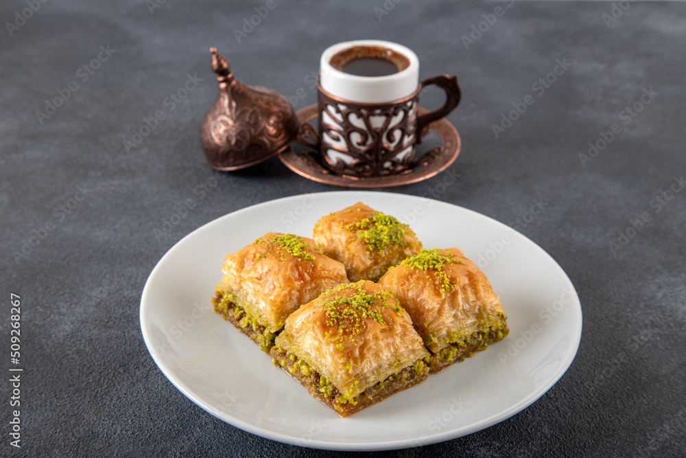 Pistachio baklava on a white plate with Turkish coffee
Pistachio baklava on a white plate with Turkish coffee