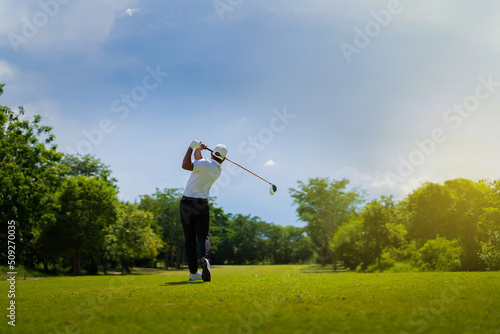 Asian man golfing on the course. In summer