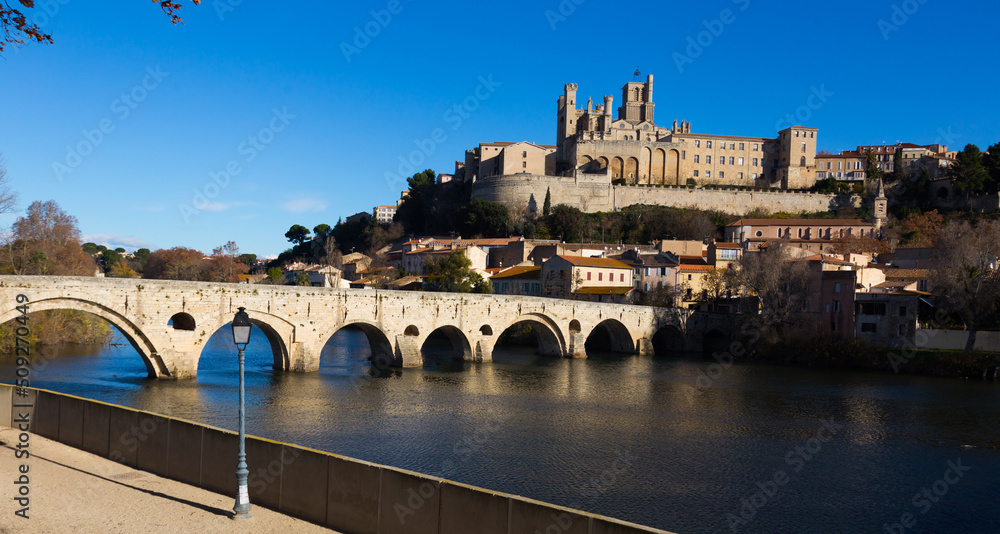 Arched Old Bridge over Orb river and medieval cathedral of Saint Nazaire in Beziers