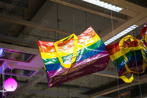 A rainbow colorful shopping bag is hanging from ceiling at the shopping store. Decorating for the pride month festival and symbol. Object photo.