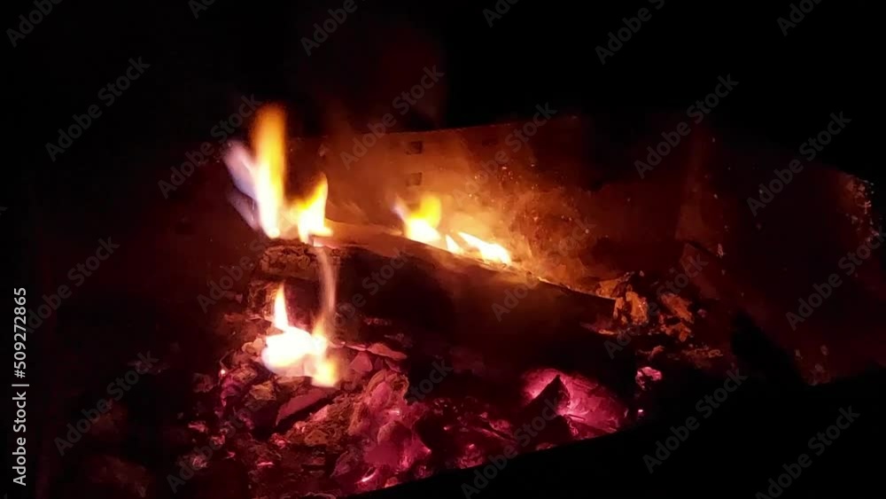 Apple log burning at night in open fireplace. Charcoal glowing in the dark with lots of smoke. Apple log burning at night in open fireplace. Charcoal glowing in the dark with lots of smoke.