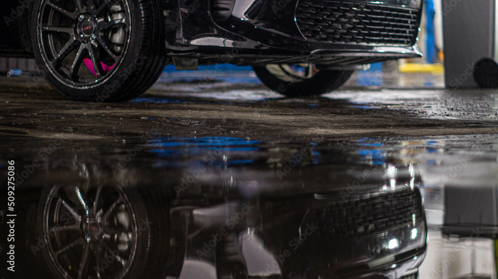 car on wet floor with reflections