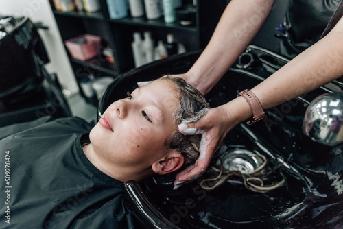 Hair wash. Hairdresser wahsing her customers hair with shampoo