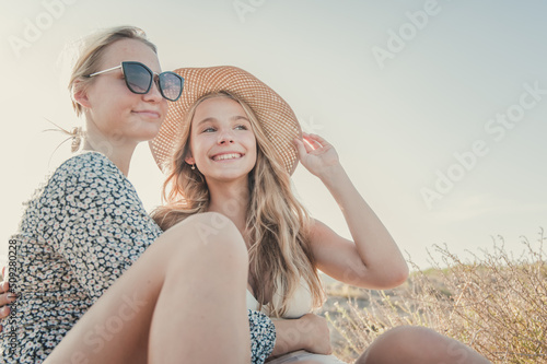 Czech teenagers girlfriends couple enjoy the sunset at a Spanish beach during summer vacations. Moments of complicity between two women who love each other. photo