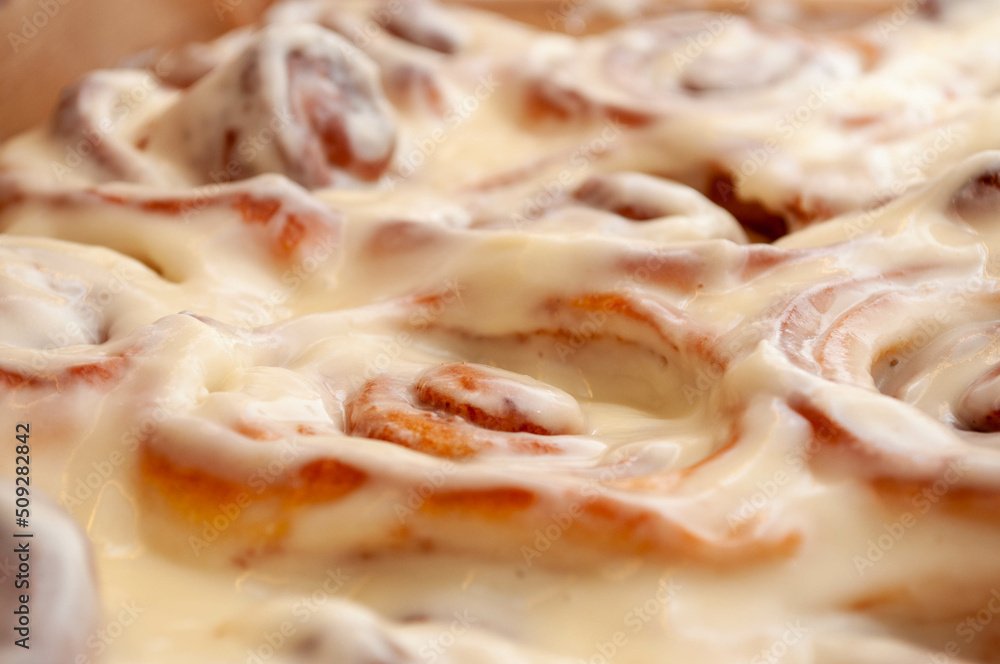 Closeup of several cinnamon buns.Beautiful fresh cinnamon rolls close-up on wooden grunge texture table. Fragrant homemade cakes, Cinnabon. A Cup of tea on a white saucer, cinnamon sticks. Closeup of several cinnamon buns.Beautiful fresh cinnamon rolls close-up on wooden grunge texture table. Fragrant homemade cakes, Cinnabon. A Cup of tea on a white saucer, cinnamon sticks.