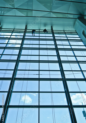 Extreme work. Cleaning the glass of a building at a height takes courage and challenges adrenaline 
