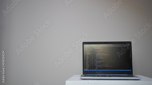 Opened laptop with code on the screen on the table