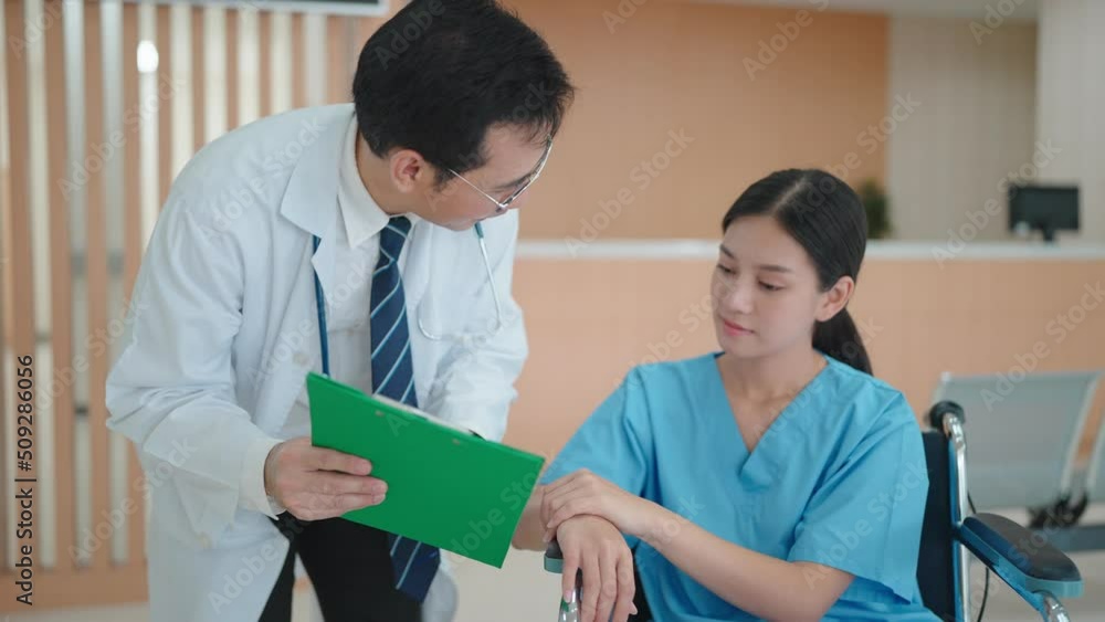 Medical professional describes the condition of an Asian woman on a wheelchair in hospital