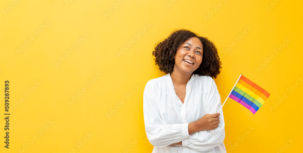 Portrait of African woman waving LGBTQ rainbow flag for coming out of the closet in pride month to promote marriage equality and differences of homosexual and discrimination concept Portrait of African woman waving LGBTQ rainbow flag for coming out of the closet in pride month to promote marriage equality and differences of homosexual and discrimination concept