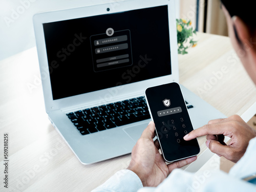 Two factor authentication or 2FA concept. Safety shield icon while access on phone with laptop for validate password, Identity verification, cybersecurity with biometrics authentication technology. photo