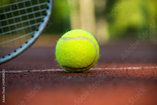 Yellow tennis ball near racquet and white line © NetPix