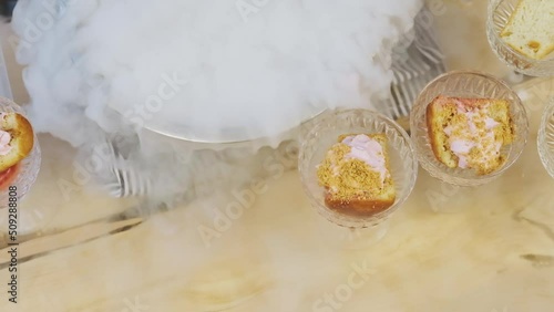 Cooking in restaurant. Cooker at work. Proffessional chef in gloves cooks dessert with dry ice. Chef pours water into bowl with dry ice. Slow motion.