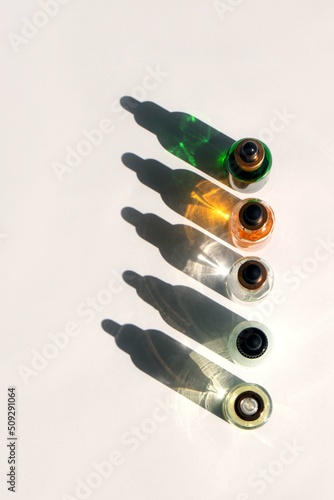 A glass bottles with oil or serum with beautiful shadows from the morning sun Natural Organic Spa Cosmetic concept. . Front view. High quality photo